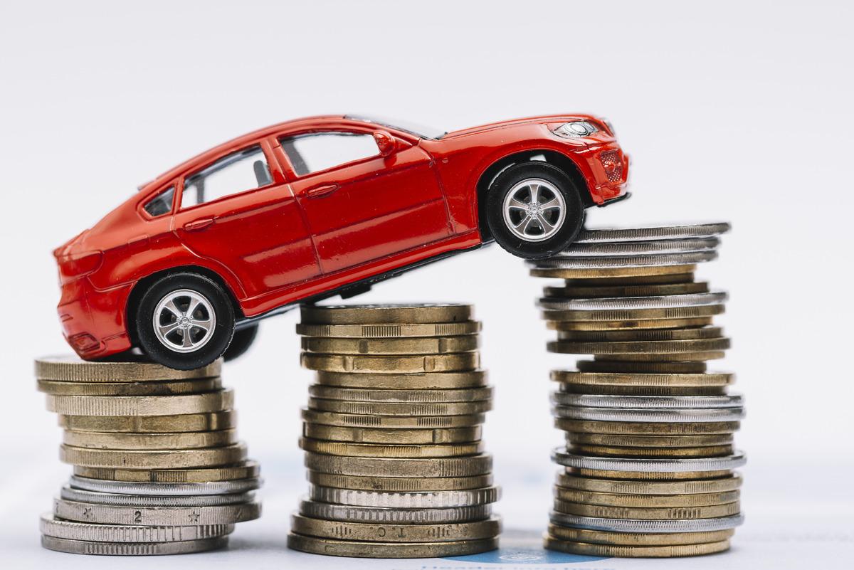 toy-red-car-stack-increasing-coins-against-white-background